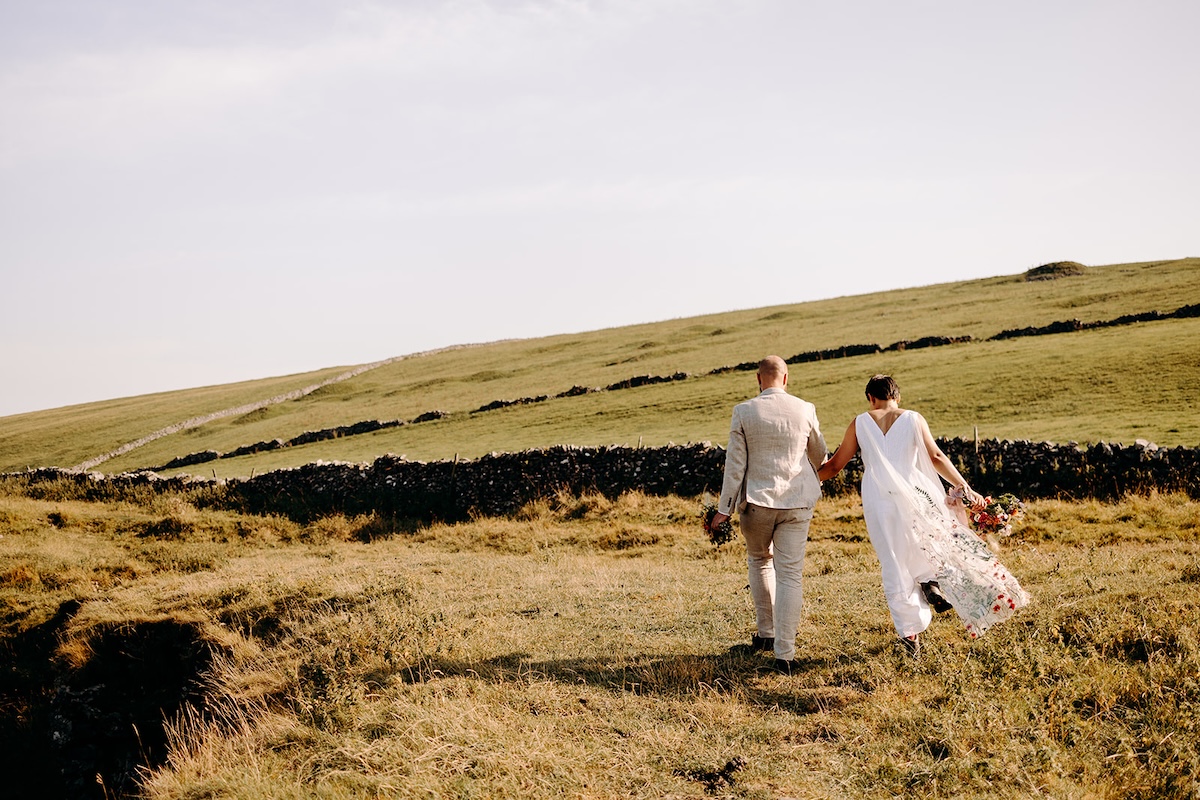 Couple standing together against sweeping hills captured by a Peak District elopement photographer.