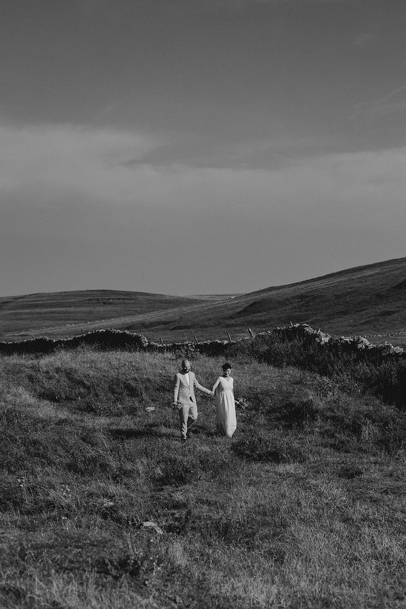 Black and white couple’s portrait on cliffs photographed by a Peak District elopement photographer.