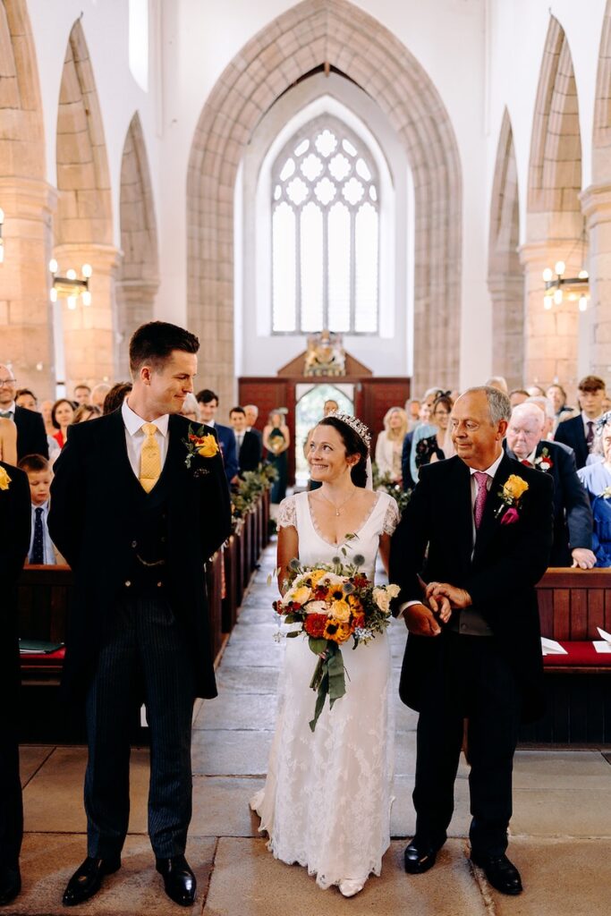 Natural moment of the the bride seeing the groom for the first time at the top of the aisle.