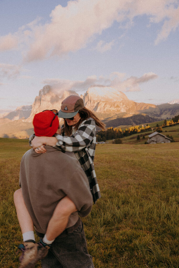Intimate piggyback moment during destination couple photoshoot in Alpe di Siusi at sunset