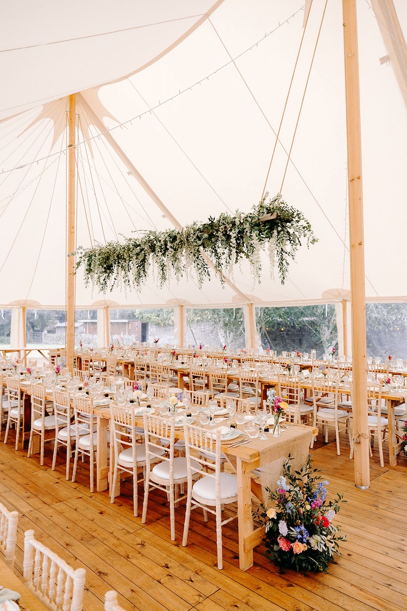 Long tables set for marquee wedding reception at Eyam Hall with soft neutral décor – Derbyshire wedding photographer detail shot.