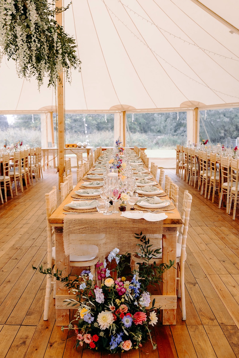 Long tables set for marquee wedding reception at Eyam Hall with soft neutral décor – Derbyshire wedding photographer detail shot.