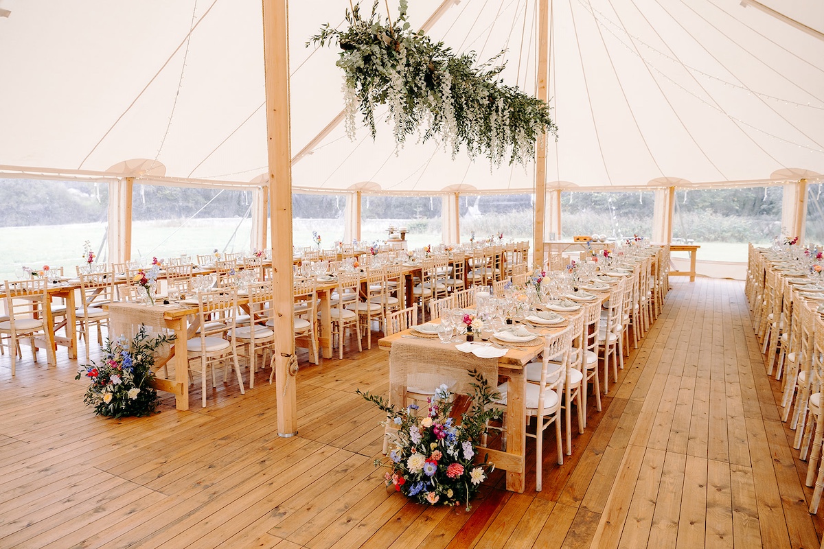 Long tables set for marquee wedding reception at Eyam Hall with soft neutral décor – Derbyshire wedding photographer detail shot.