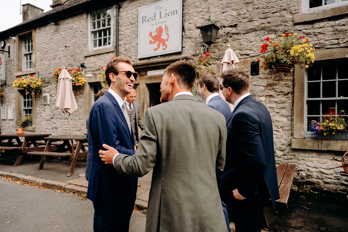 Groom greeting guests and shaking hands before the ceremony in Eyam village.