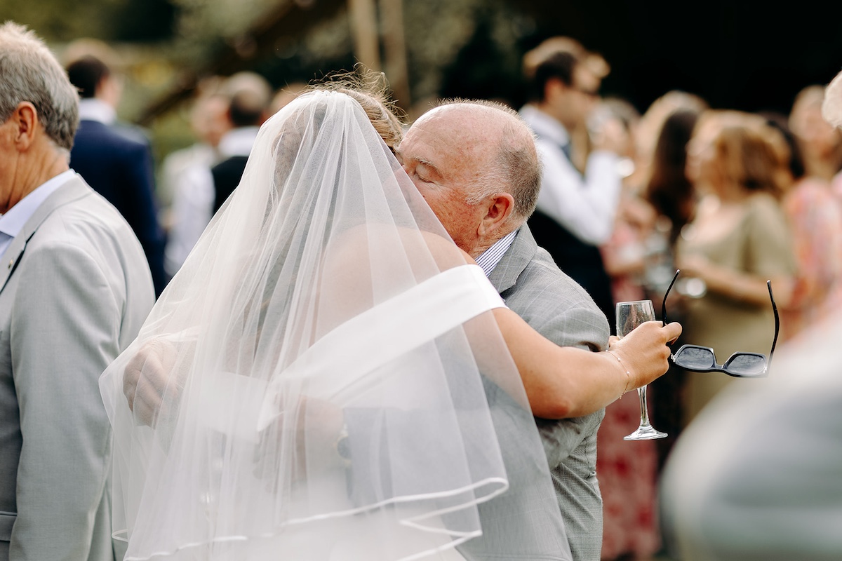 Guests mingling outside marquee during wedding reception at Eyam Hall in Derbyshire.