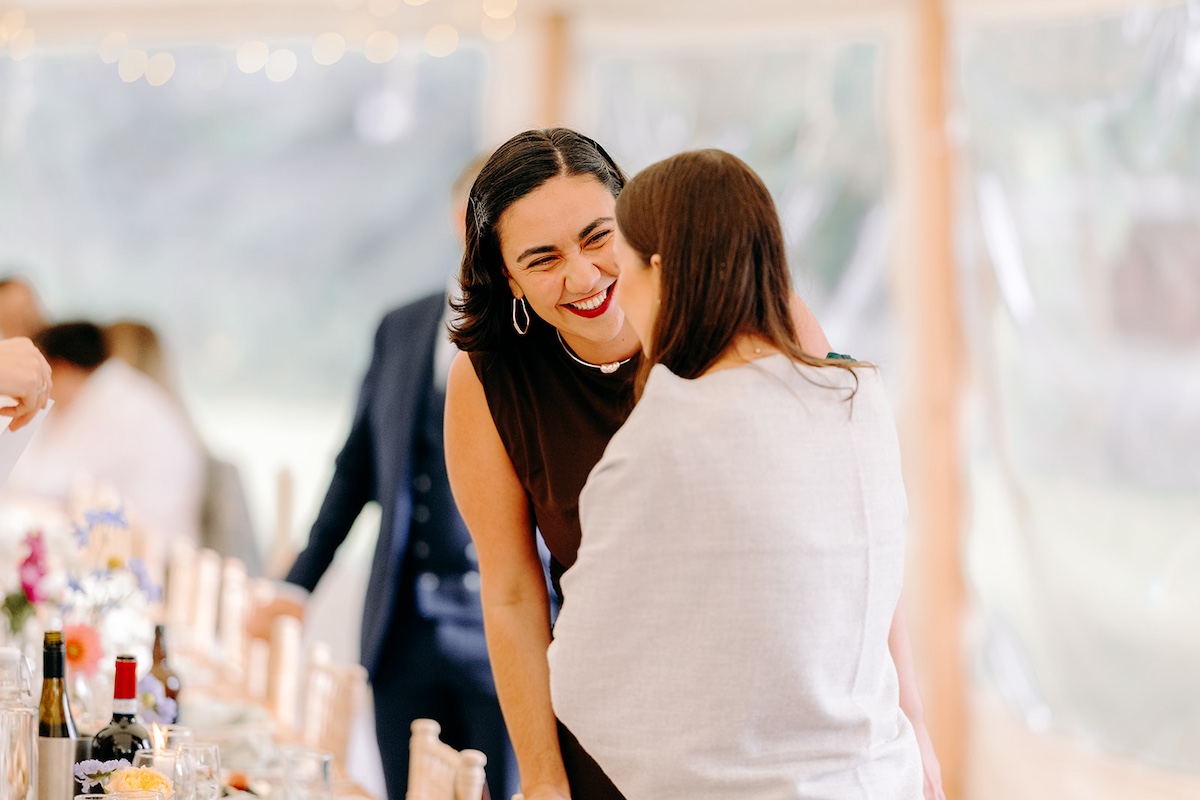 Wedding guests laughing and cheering together during drinks reception at Eyam Hall marquee wedding.