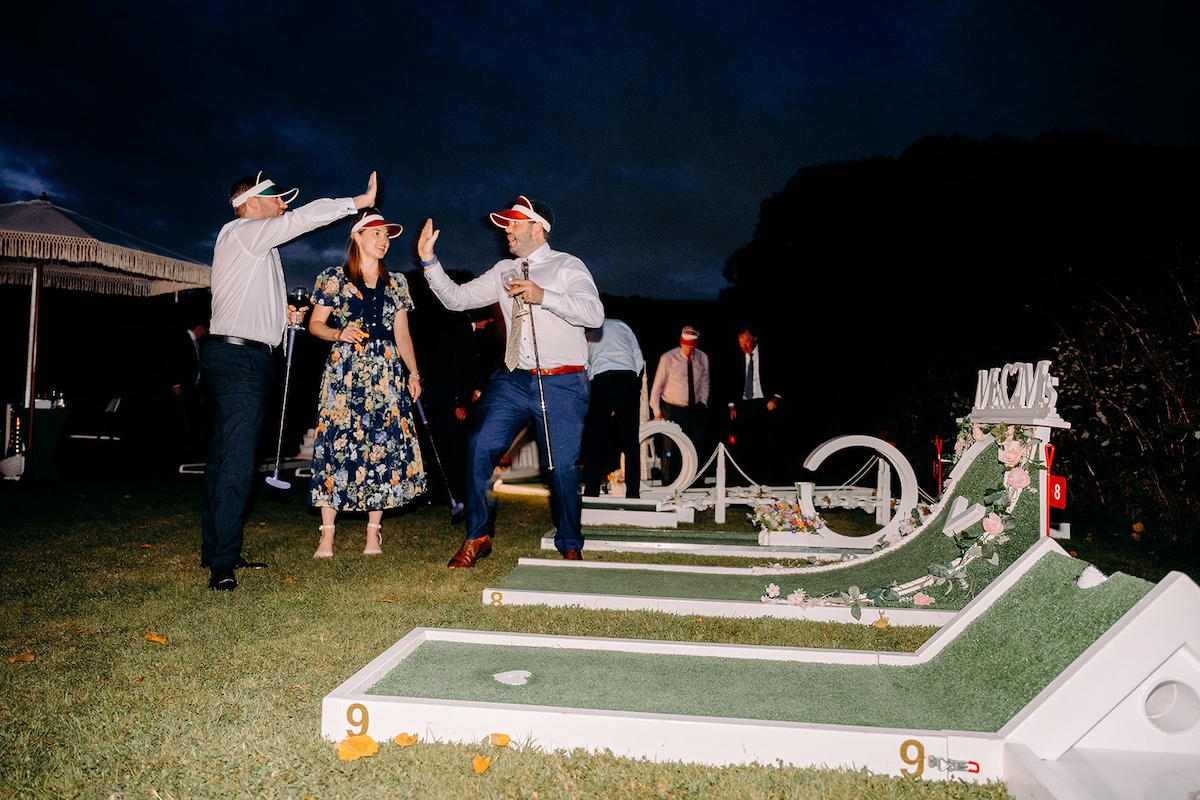 Guests playing mini golf during evening wedding reception at Eyam Hall.