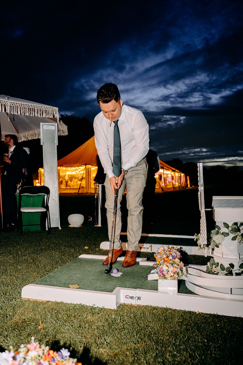 Guests playing mini golf during evening wedding reception at Eyam Hall.