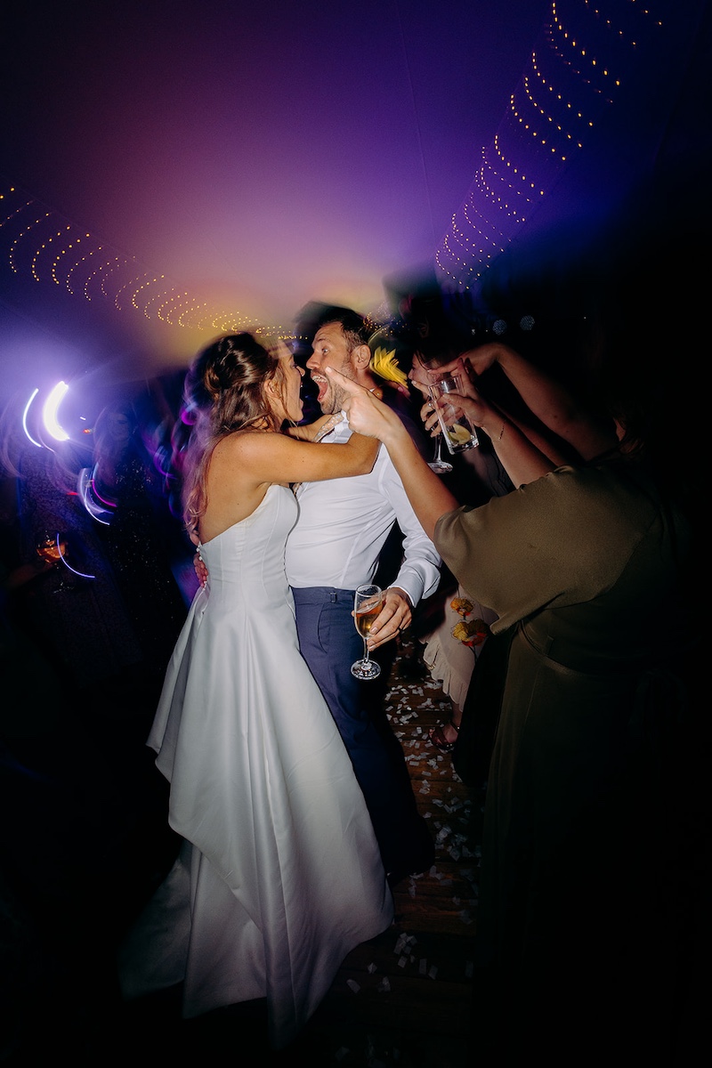 Bride & groom hugging while laughing on the dance floor – fun wedding photography in Derbyshire.