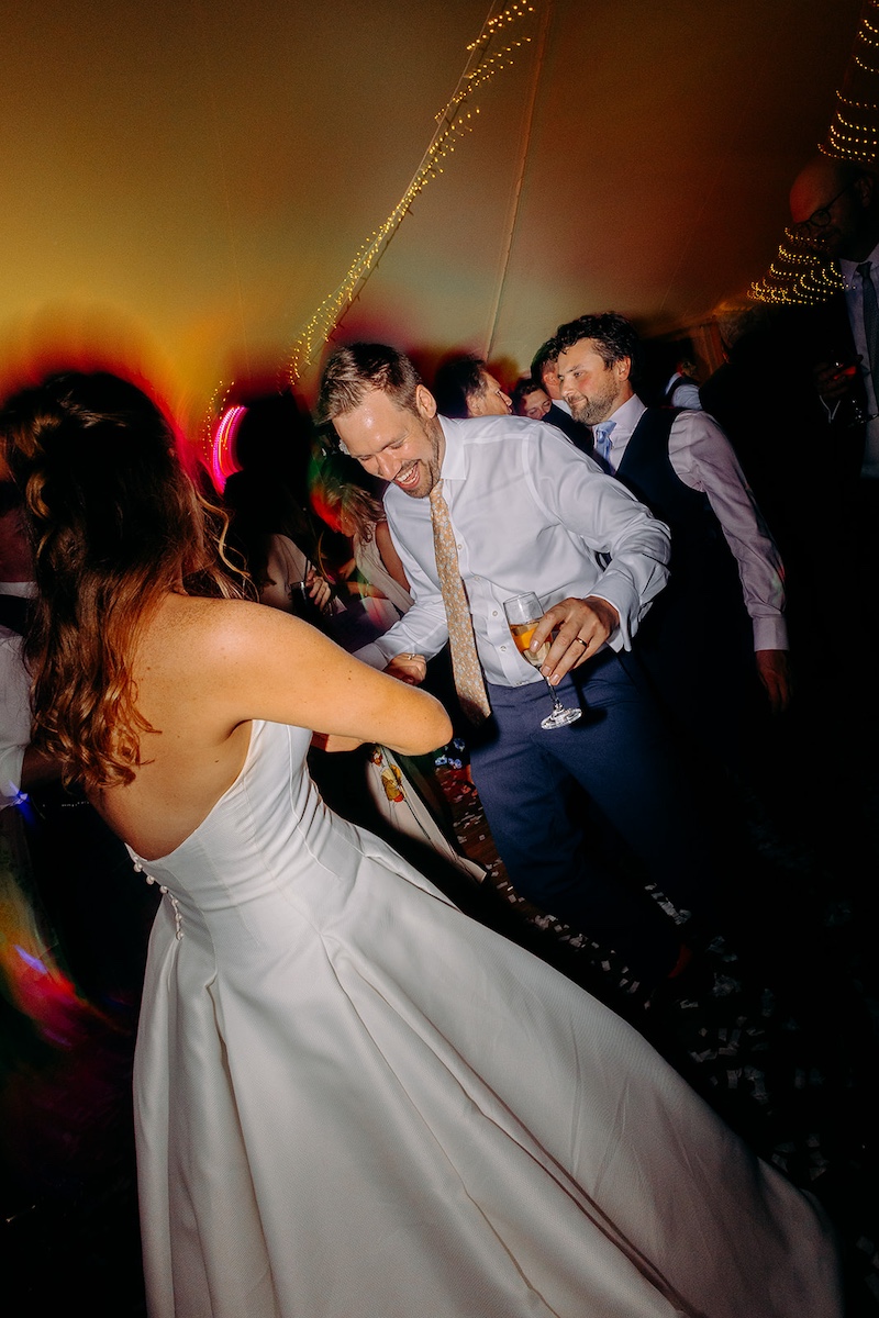 Bride & groom hugging while laughing on the dance floor – fun wedding photography in Derbyshire.