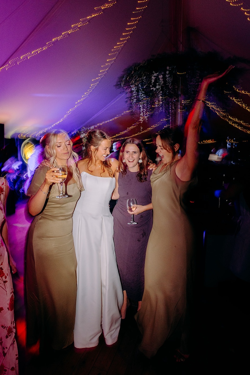Fun group photo of bride and friends on the dancefloor at Eyam Hall wedding.