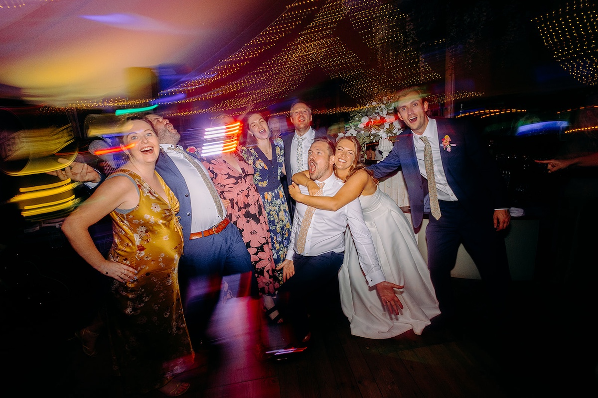 More dance floor celebrations with guests singing and arms in the air at Eyam Hall marquee reception.