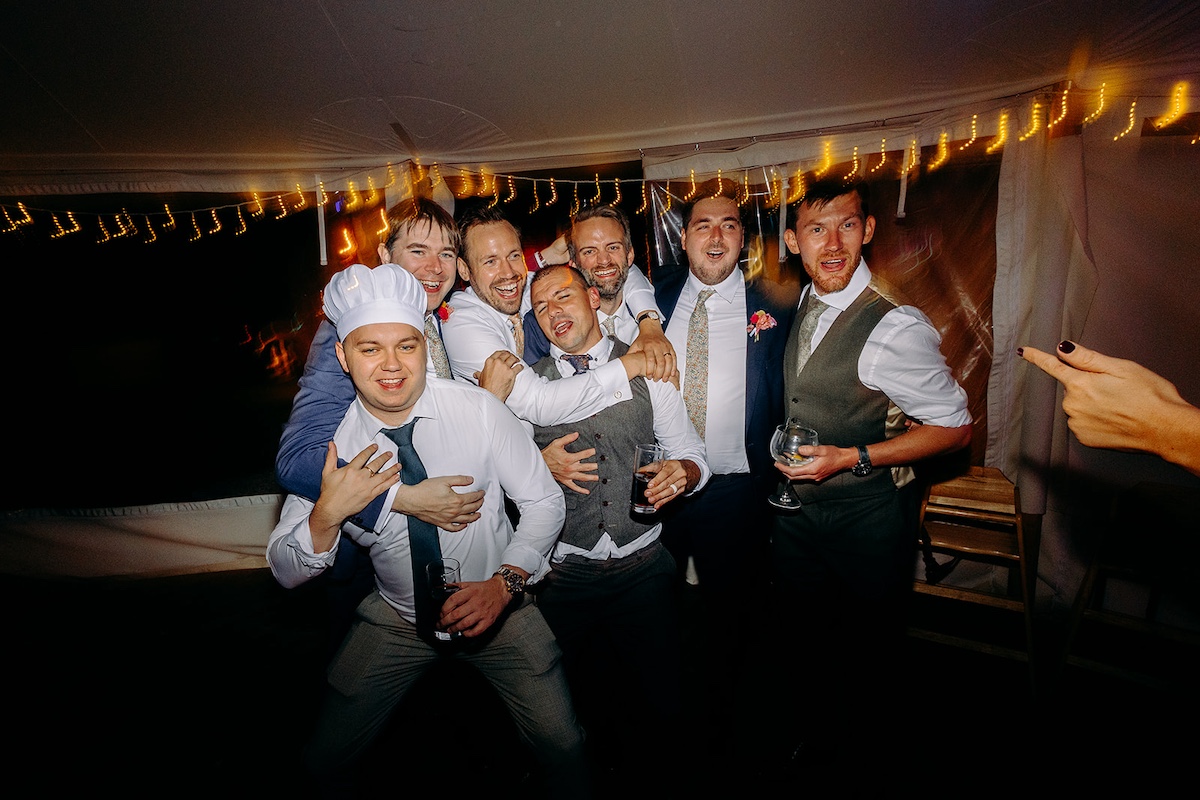 Candid dance floor moment with colourful lighting during Eyam Hall wedding celebration in Derbyshire.
