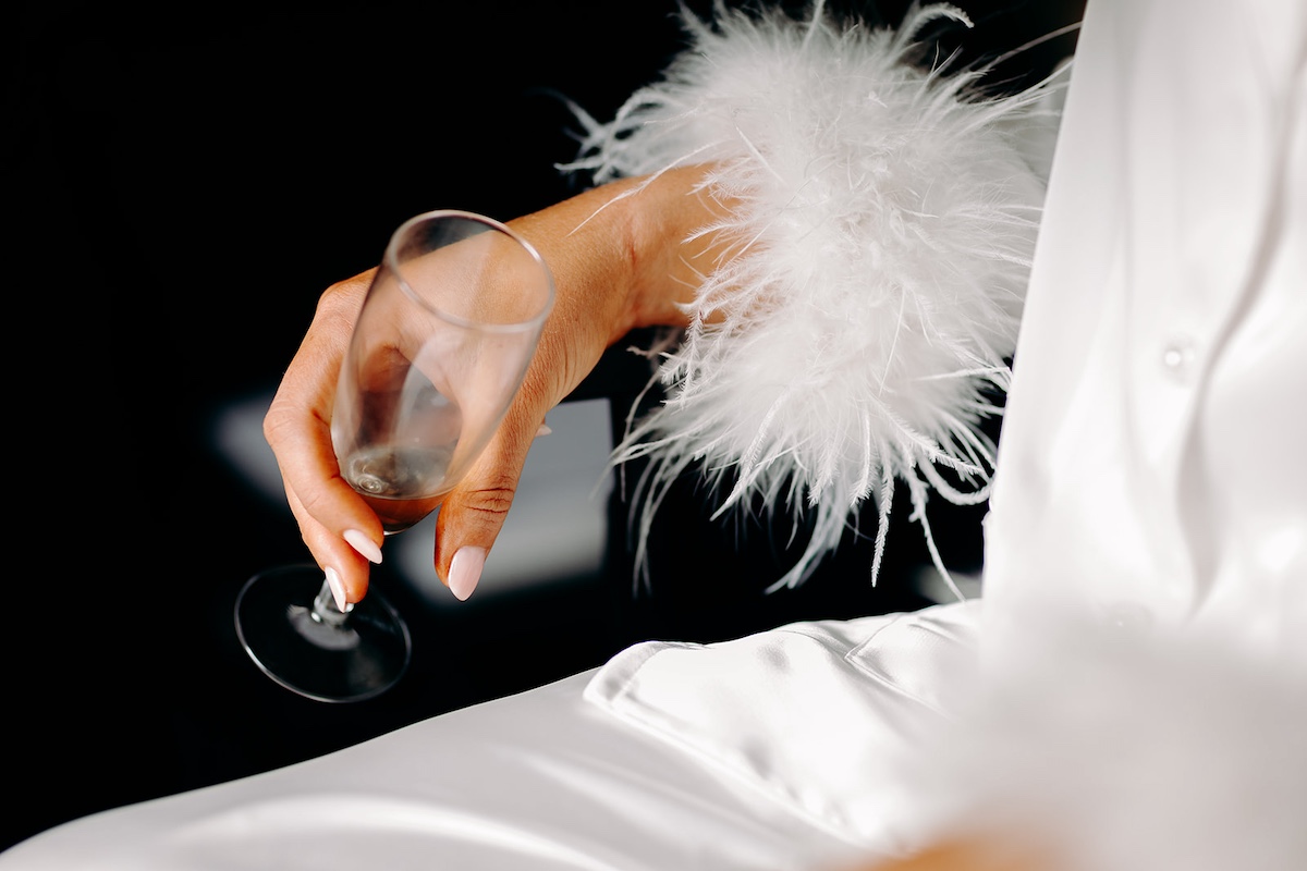 Close-up of bride holding champagne glass on the wedding morning at Eyam Hall.