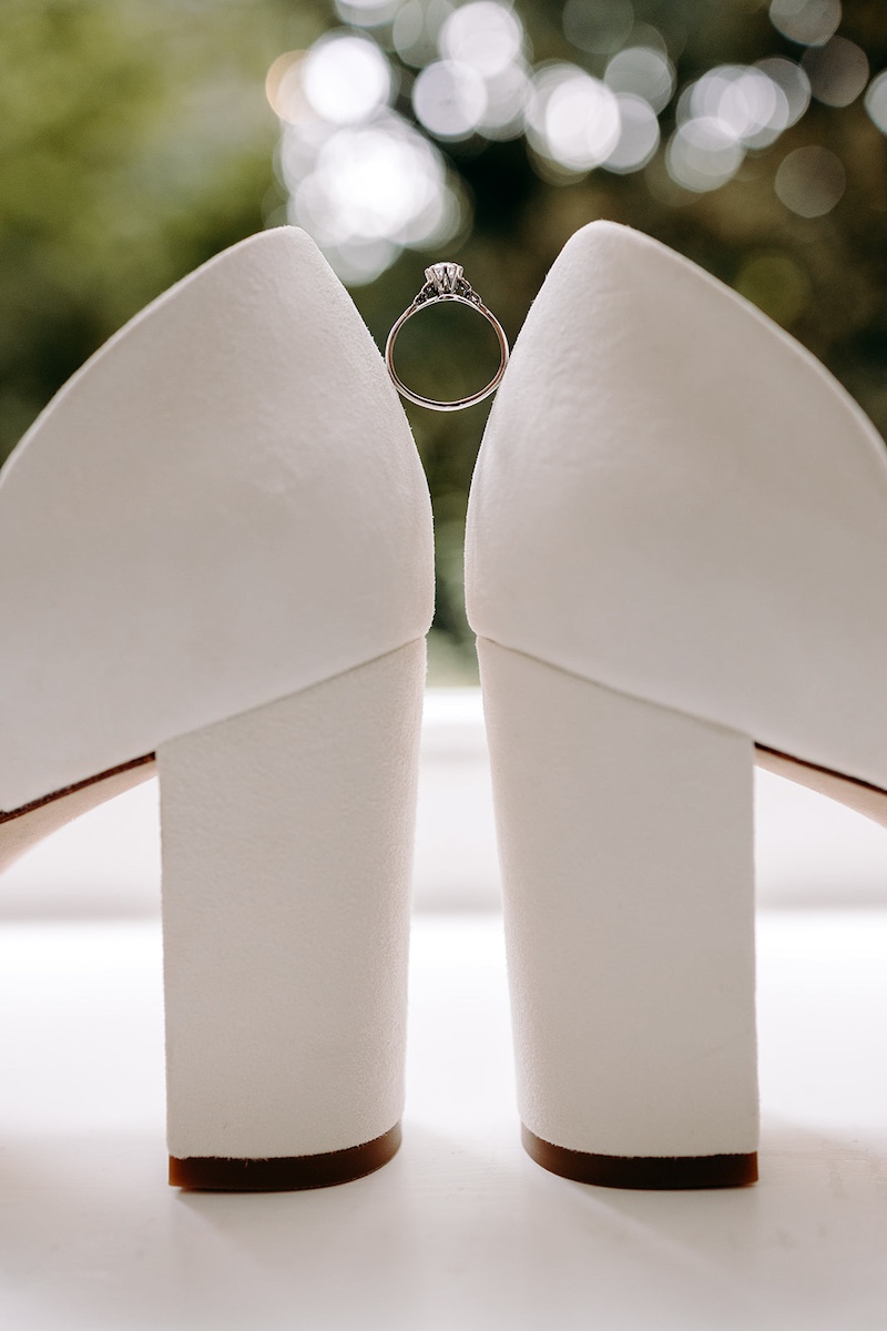 White bridal shoes photographed against soft fabric light – elegant Eyam Hall wedding detail shot.