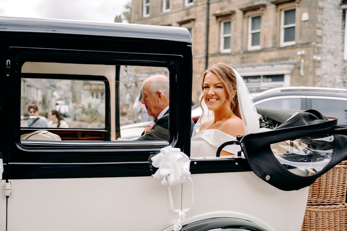 Bride arriving for Peak District church wedding, with her dad in a wedding car.