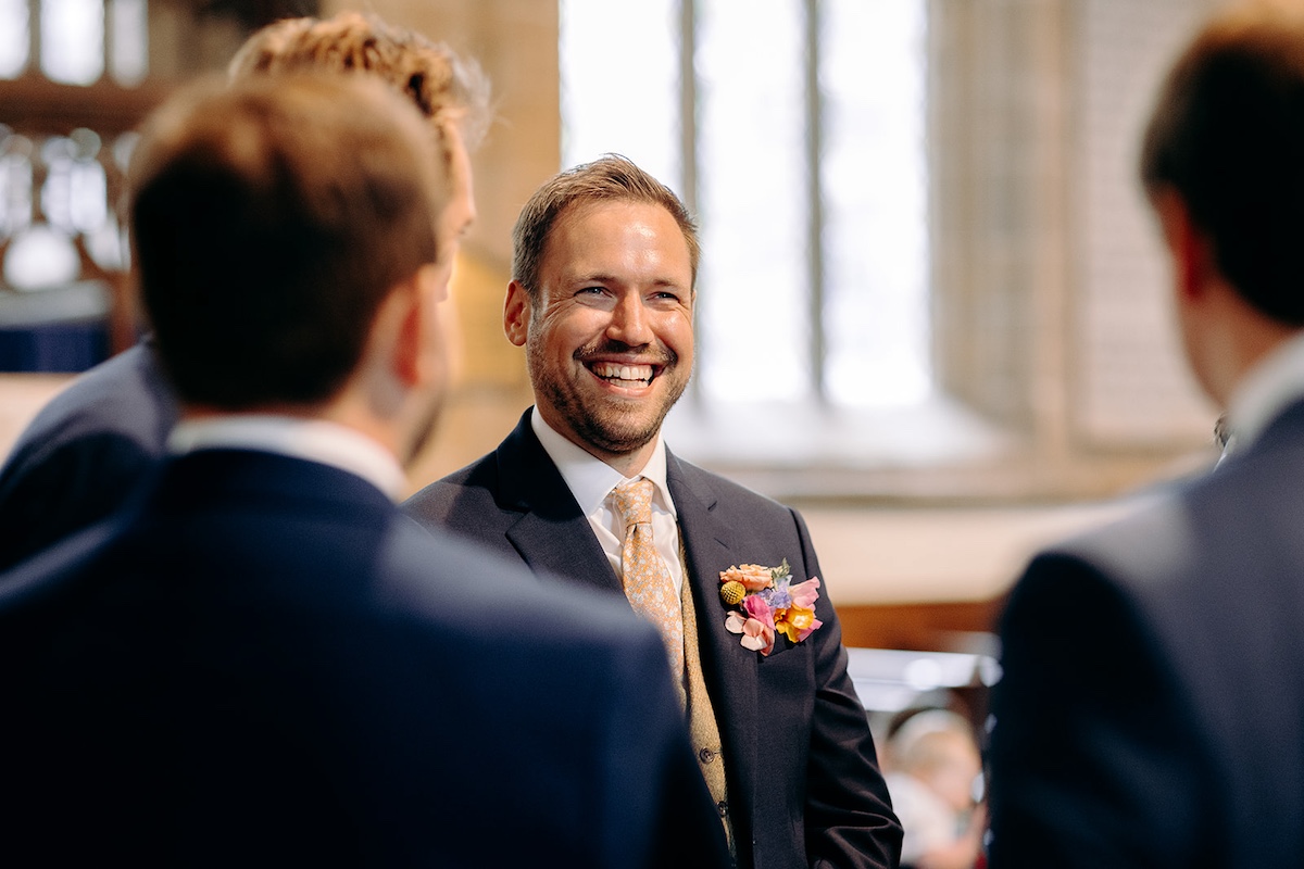 Groom waiting nervously before ceremony inside Eyam church in Derbyshire.