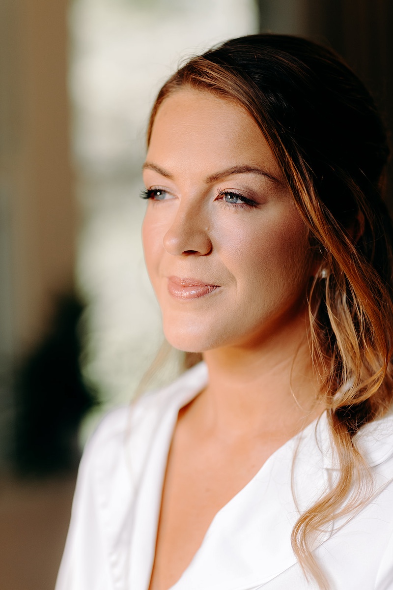 Bridal portrait in natural window light, bride smiling before her ceremony at Eyam Hall in the Peak District.