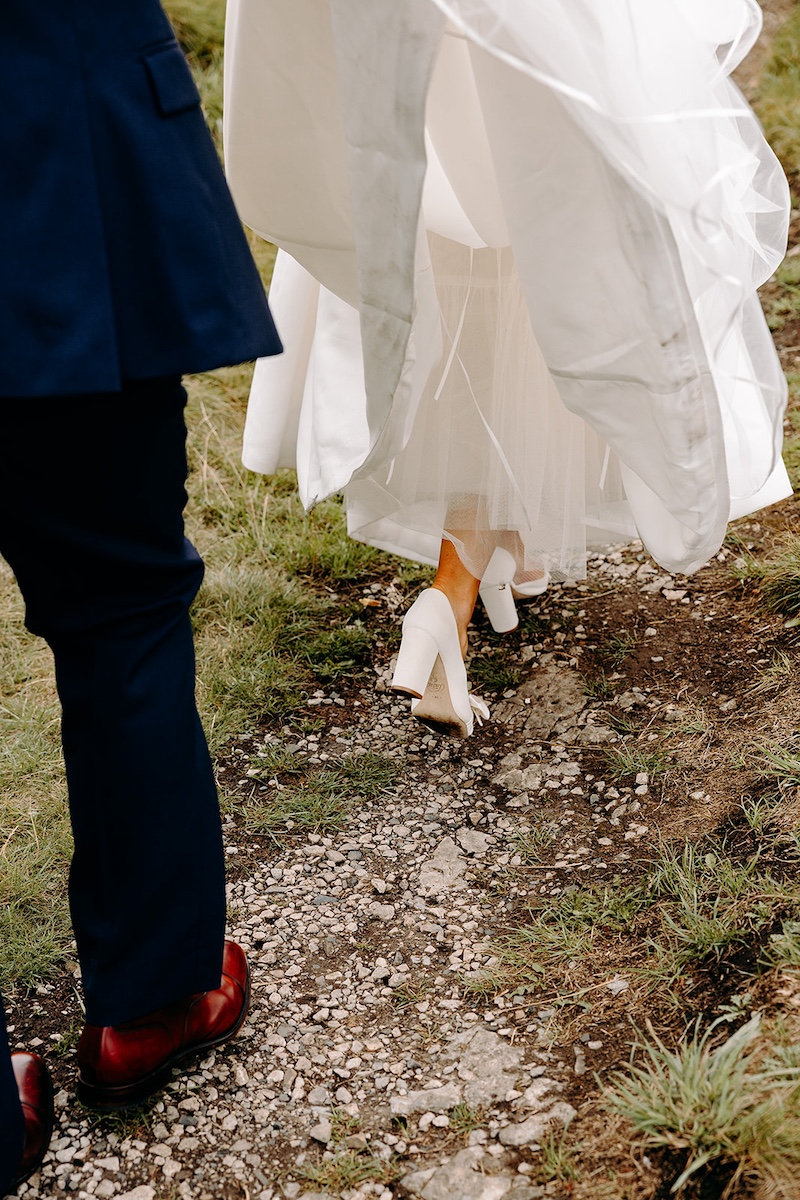 Intimate close-up of bride's wedding shoes as she walks across the Peak District moorlands.