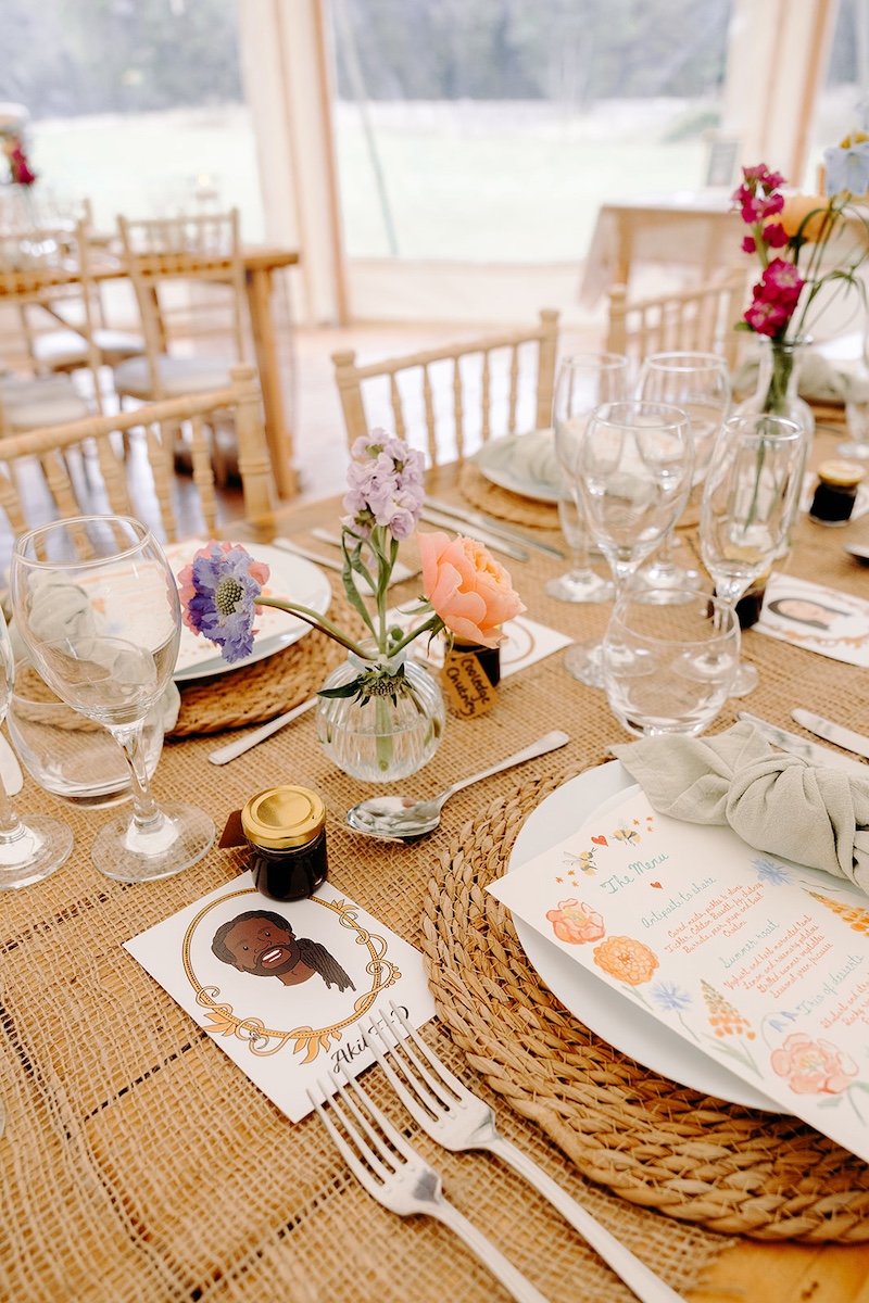 Close-up of wedding place settings with name cards and silver cutlery at Eyam Hall reception.