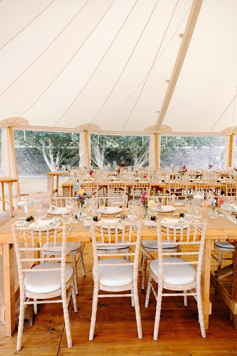 Long tables set for marquee wedding reception at Eyam Hall with soft neutral décor – Derbyshire wedding photographer detail shot.
