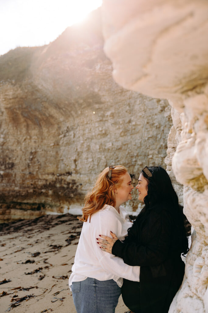 Secret proposal under chalk cliffs at Flamborough Head with couple laughing together on the beach