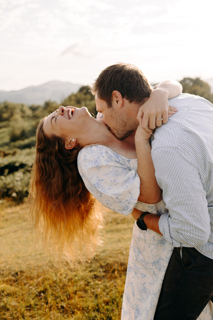 Couple spinning and laughing during playful pre-wedding shoot in North Wales hills