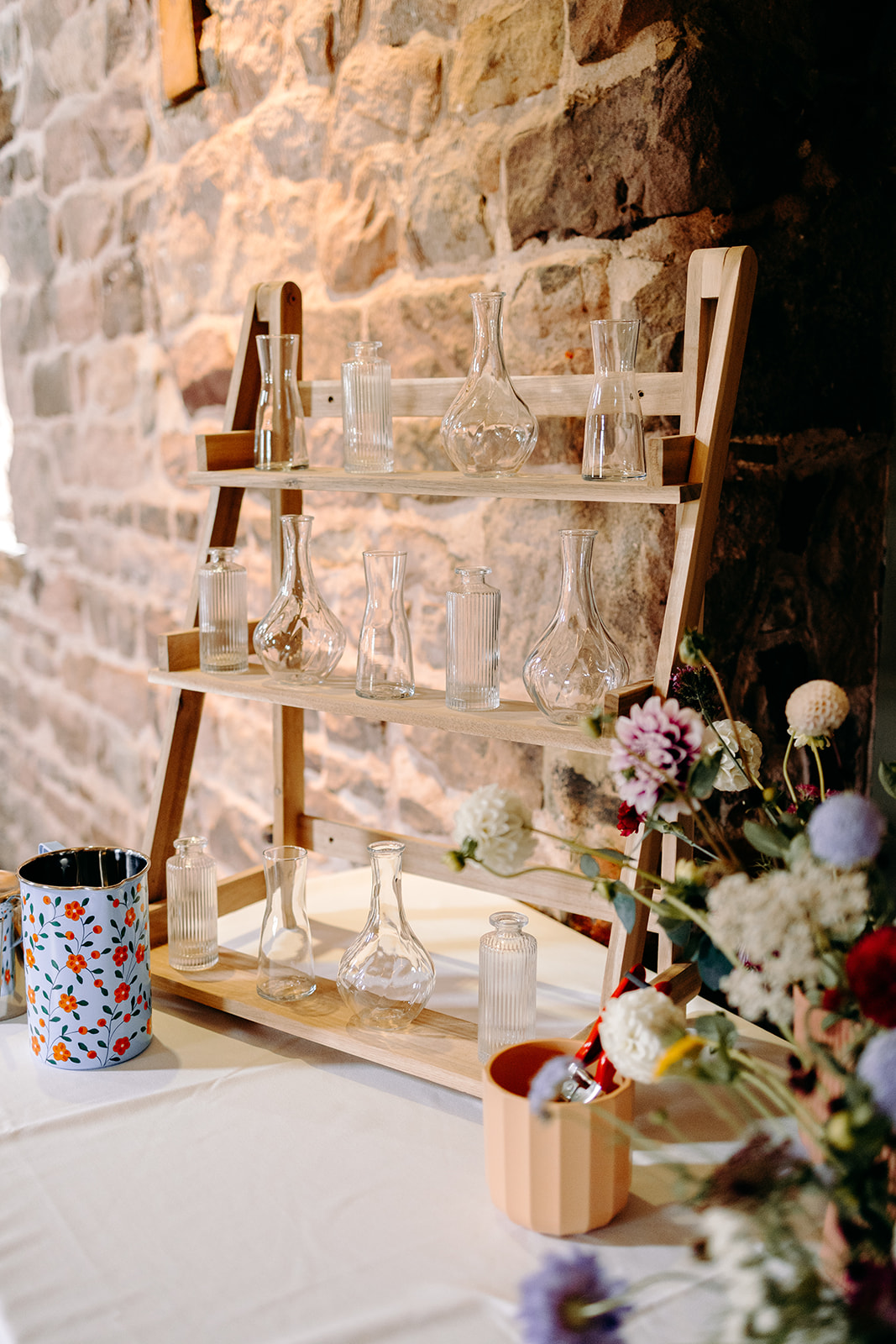 Pick your own flowers wedding table styled against rustic stone walls at Ashes Barns.