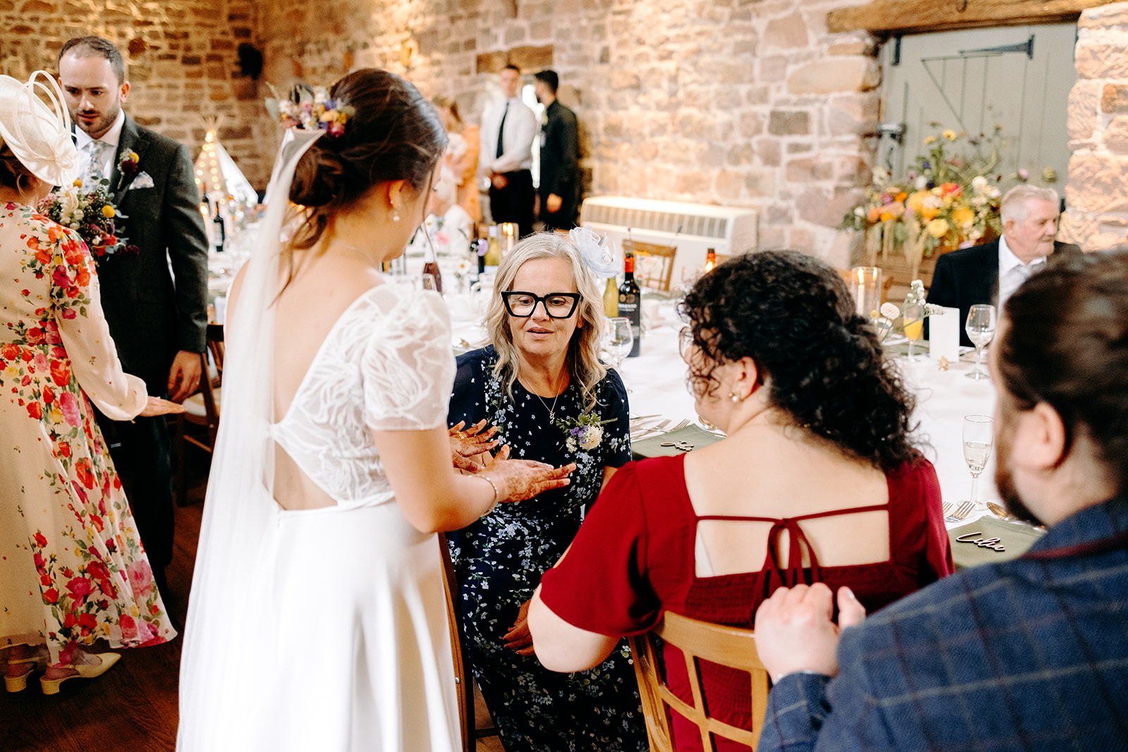 Two guests smiling together during speeches at an Ashes Barns wedding.