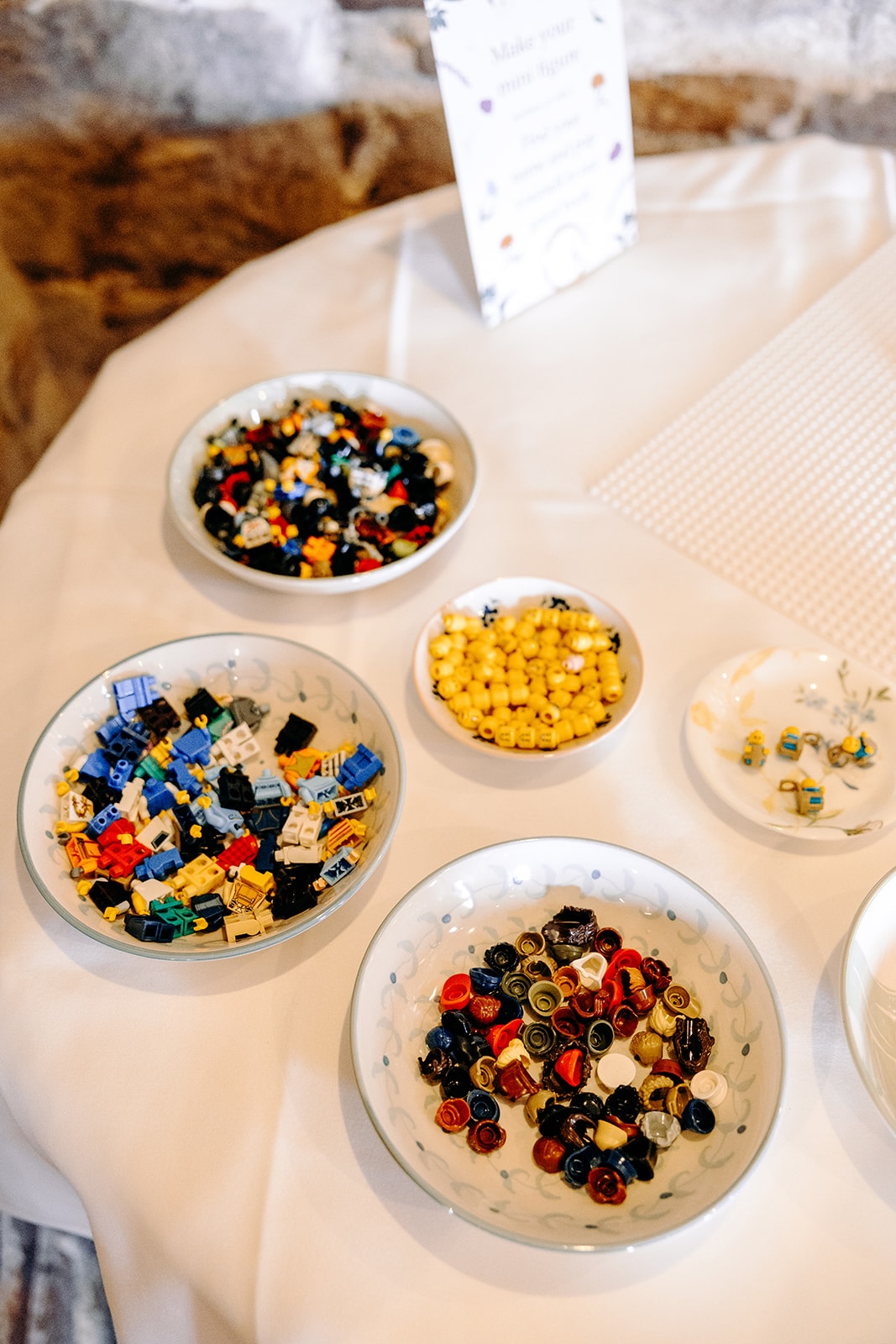 Sharing bowls of colourful lego pieces set out for an alternative guest book idea at an intimate Peak District wedding.