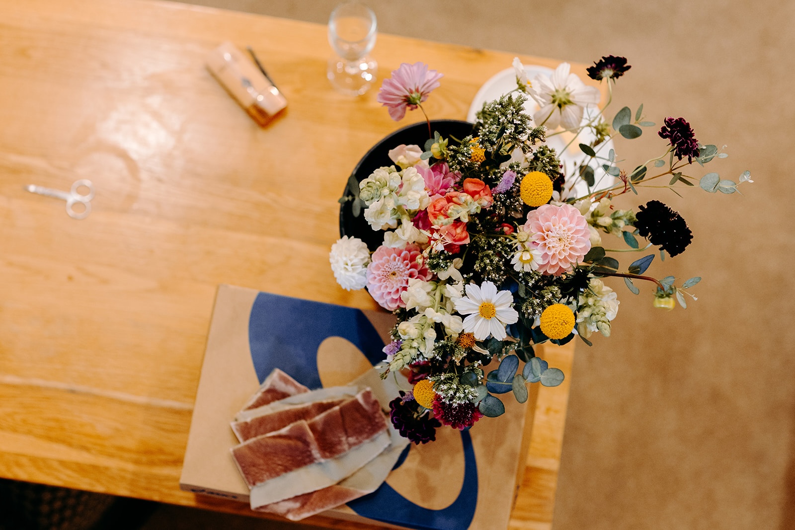 Bridal bouquet resting on a wooden table during preparations at Ashes Barns.