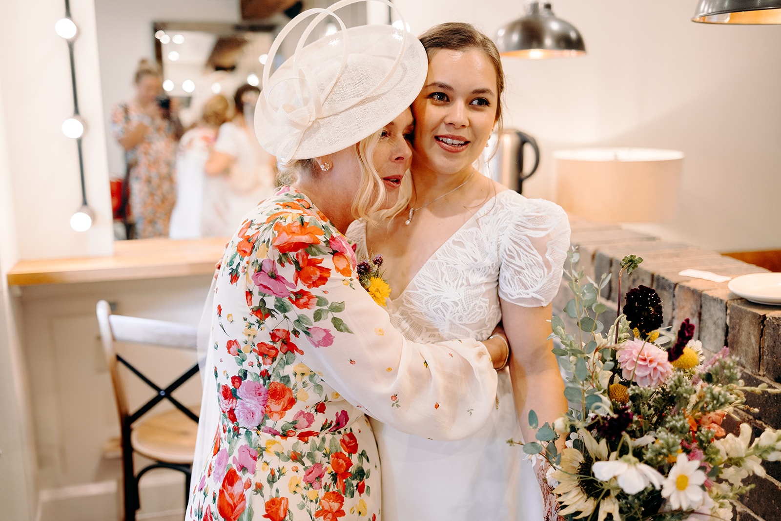 Bride & mother of the bride laughing together during final touches before the ceremony at Ashes Barns.