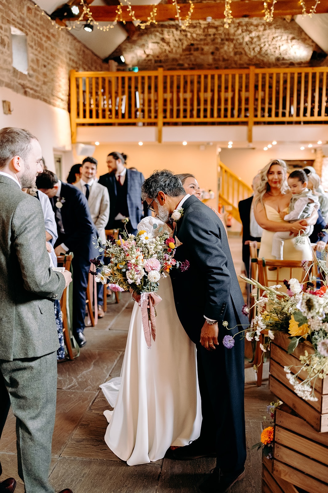 Emotional moment as the bride and father of the bride hug at the top of the aisle at Ashes Barns during the ceremony.