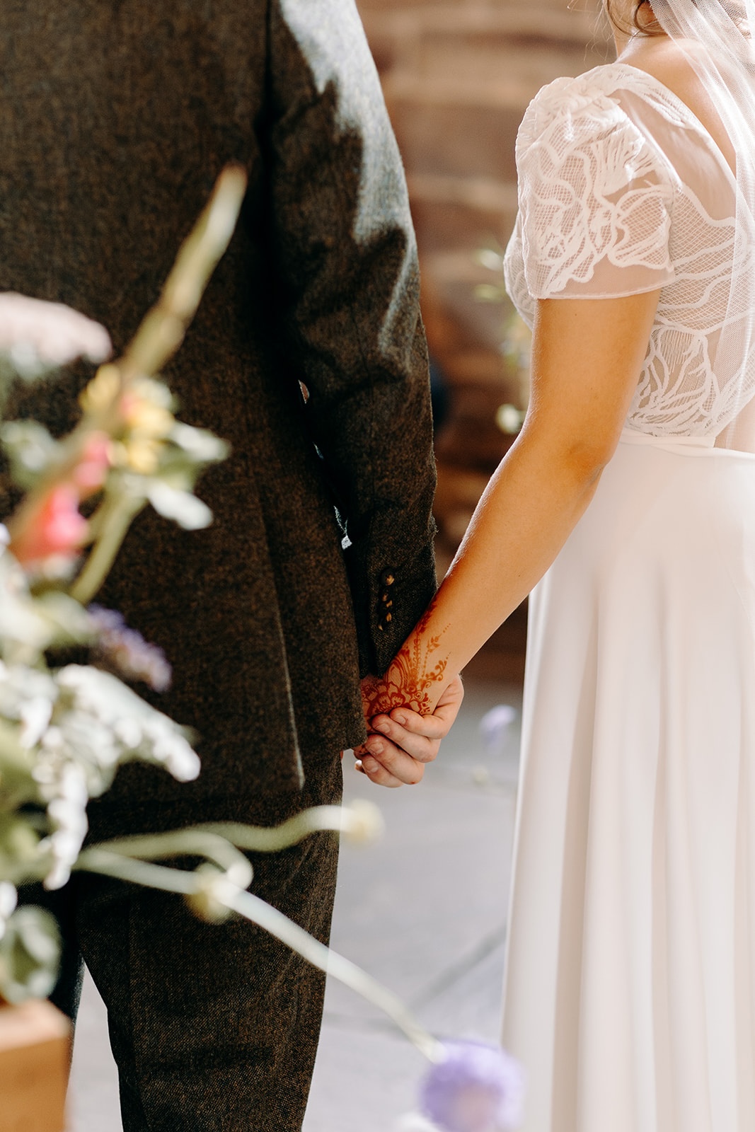 Close-up of hands during the ceremony at Ashes Barns, showing simple wedding rings.