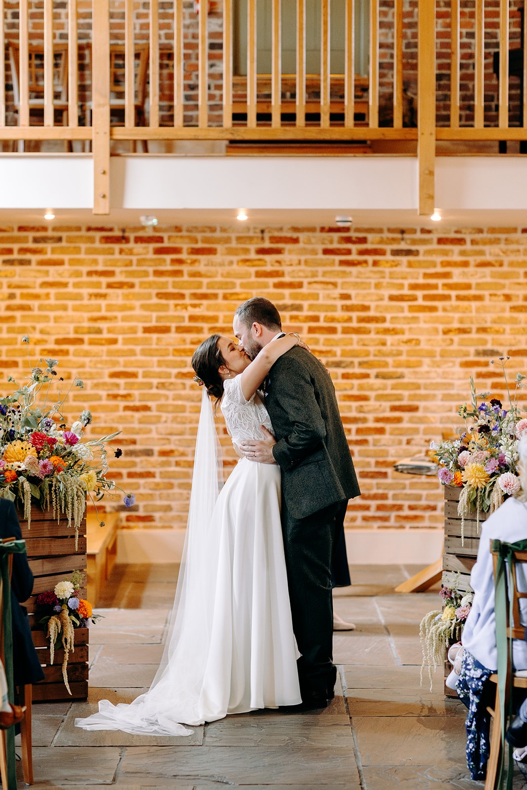 First kiss as newlyweds inside the ceremony barn at Ashes Barns.