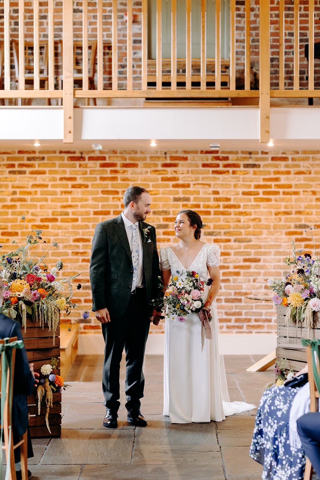 Newlyweds standing together at the front of the ceremony space at Ashes Barns.