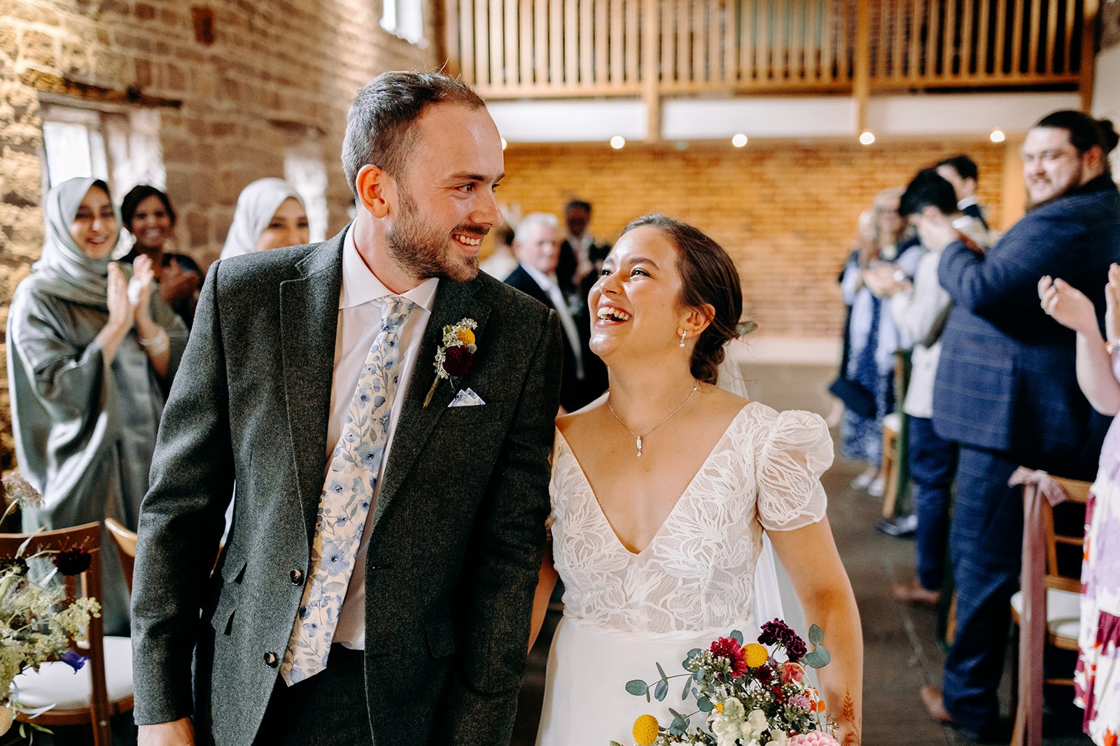 Natural, candid moment of the newlyweds laughing together after the ceremony.