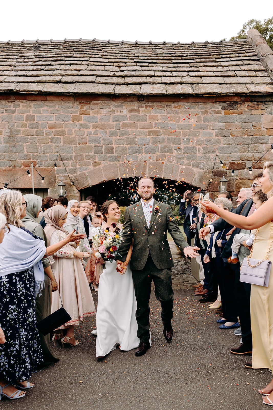 Guests throwing confetti outside Ashes Barns as the couple exit the ceremony.