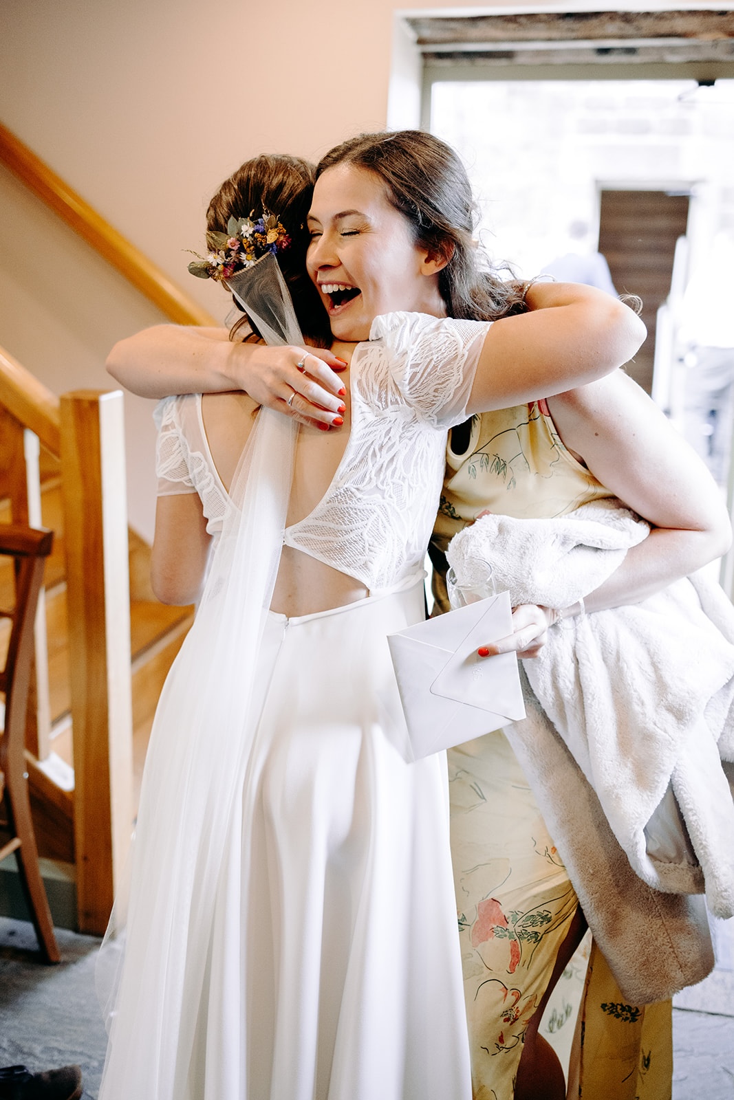 Guest embracing the bride during post-ceremony congratulations at Ashes Barns.