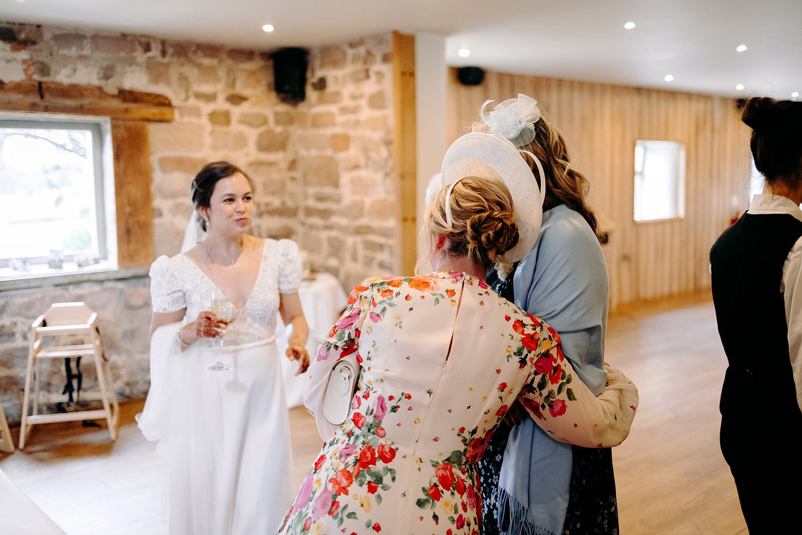 Bride hugging a guest during celebrations after the ceremony at Ashes Barns.