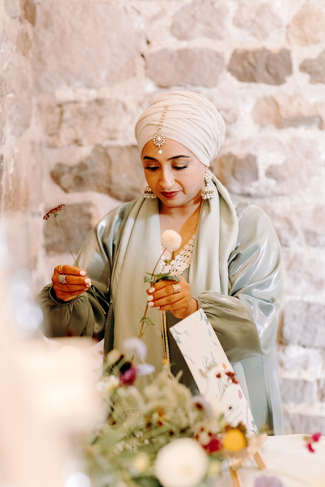 Guest adjusting wedding flowers during the Ashes Barns reception.