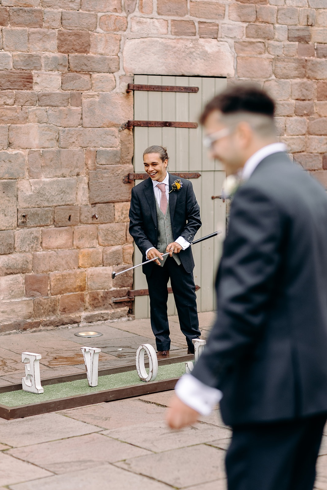 Guests playing mini golf outside the stone walls of Ashes Barns during the reception.