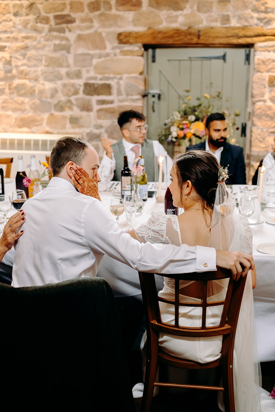 Bride & groom laughing and chatting around tables during the Ashes Barns wedding breakfast.