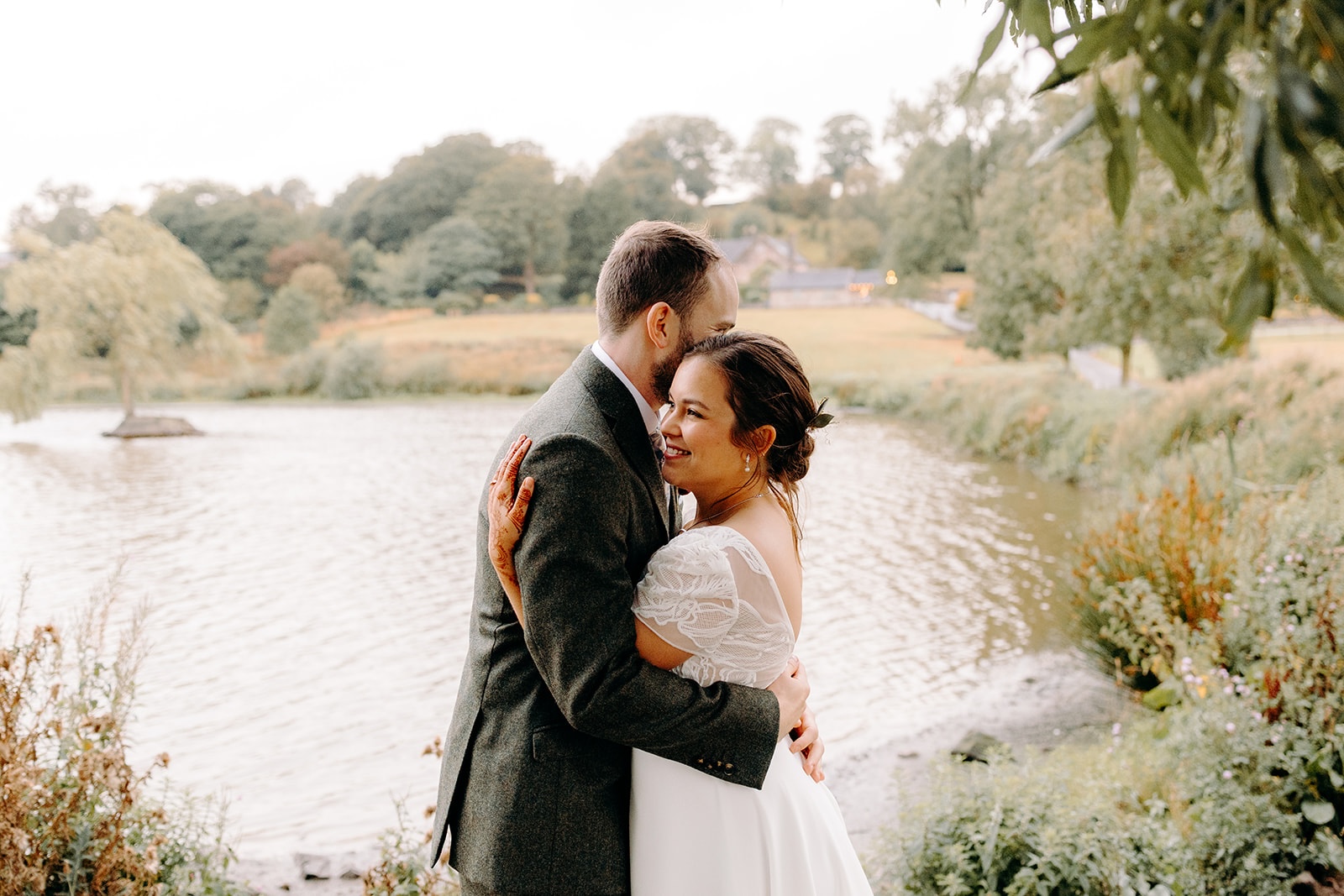 Romantic portrait of the newlyweds beside a pond in the Peak District.