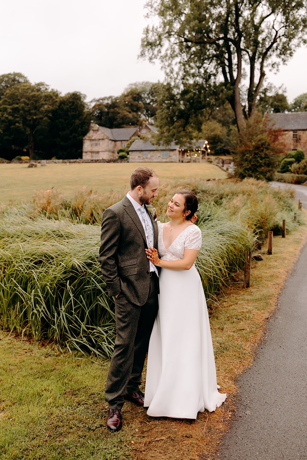 Couple standing together on a quiet path during their Ashes Barns wedding portraits.