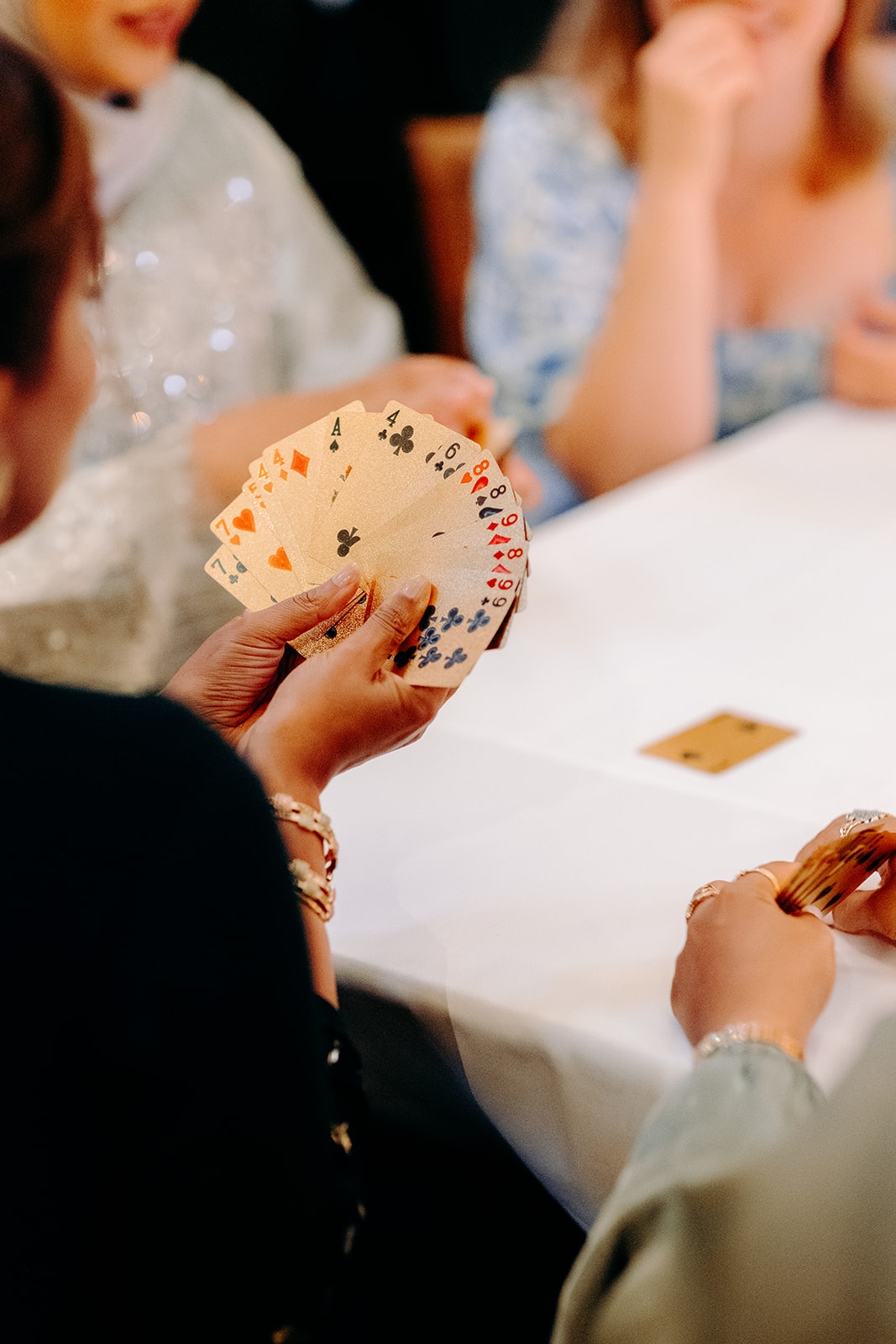 Guests gathered around a table playing cards during the relaxed evening reception at Ashes Barns.