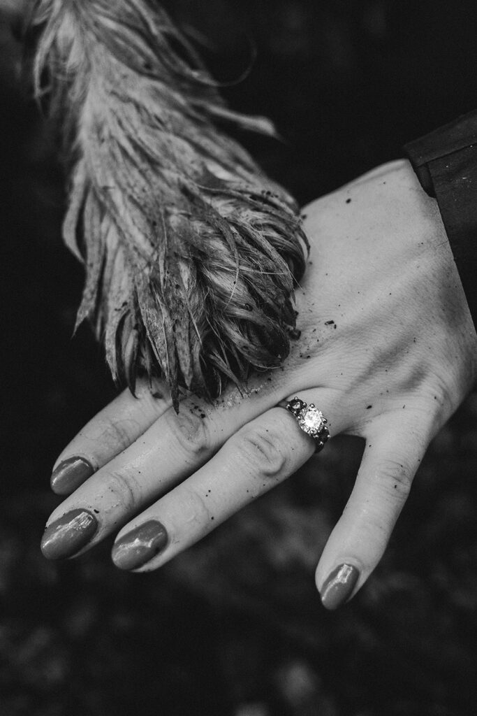 Candid portrait of engaged couple and dog during woodland proposal session in the Lake District