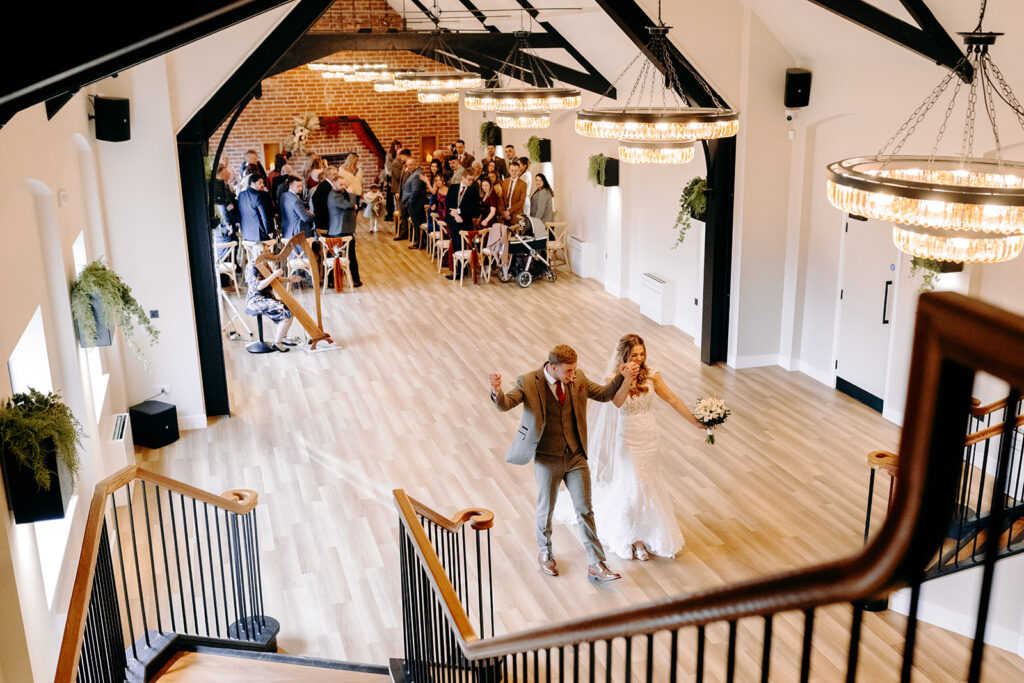 Newlyweds walking into drinks reception at Whistle Barns, photographed by a Whistle Barns wedding photographer
