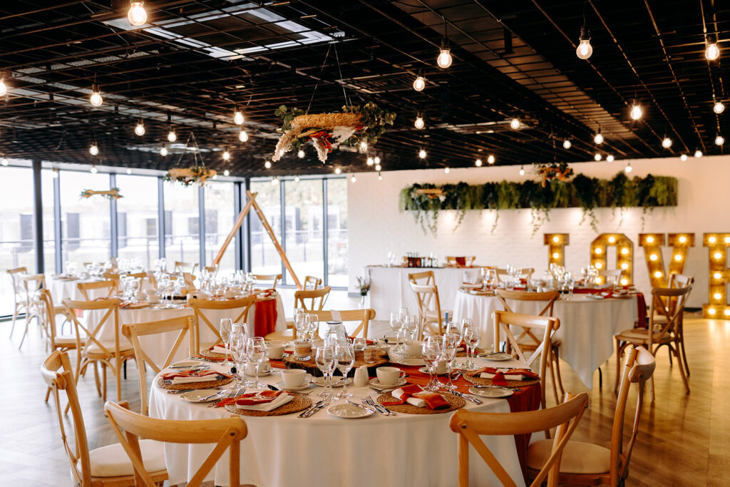Wedding breakfast tables set up inside Whistle Barns reception room, captured naturally