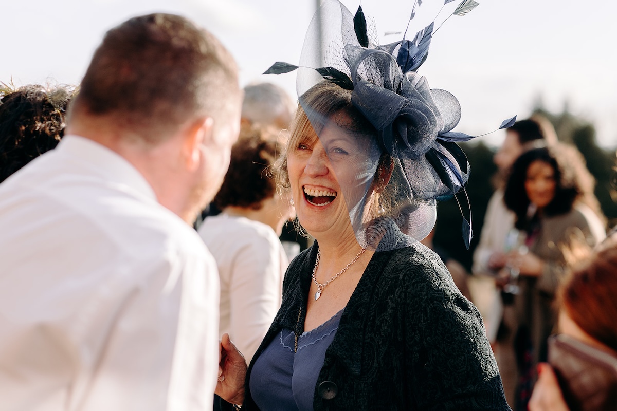 Guest laughing while posing beside a llama during the reception at The Wellbeing Farm wedding venue.